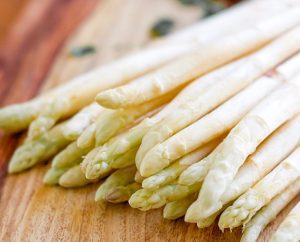 Cận cảnh búp măng tây trắng khép chặt trên thớt gỗ